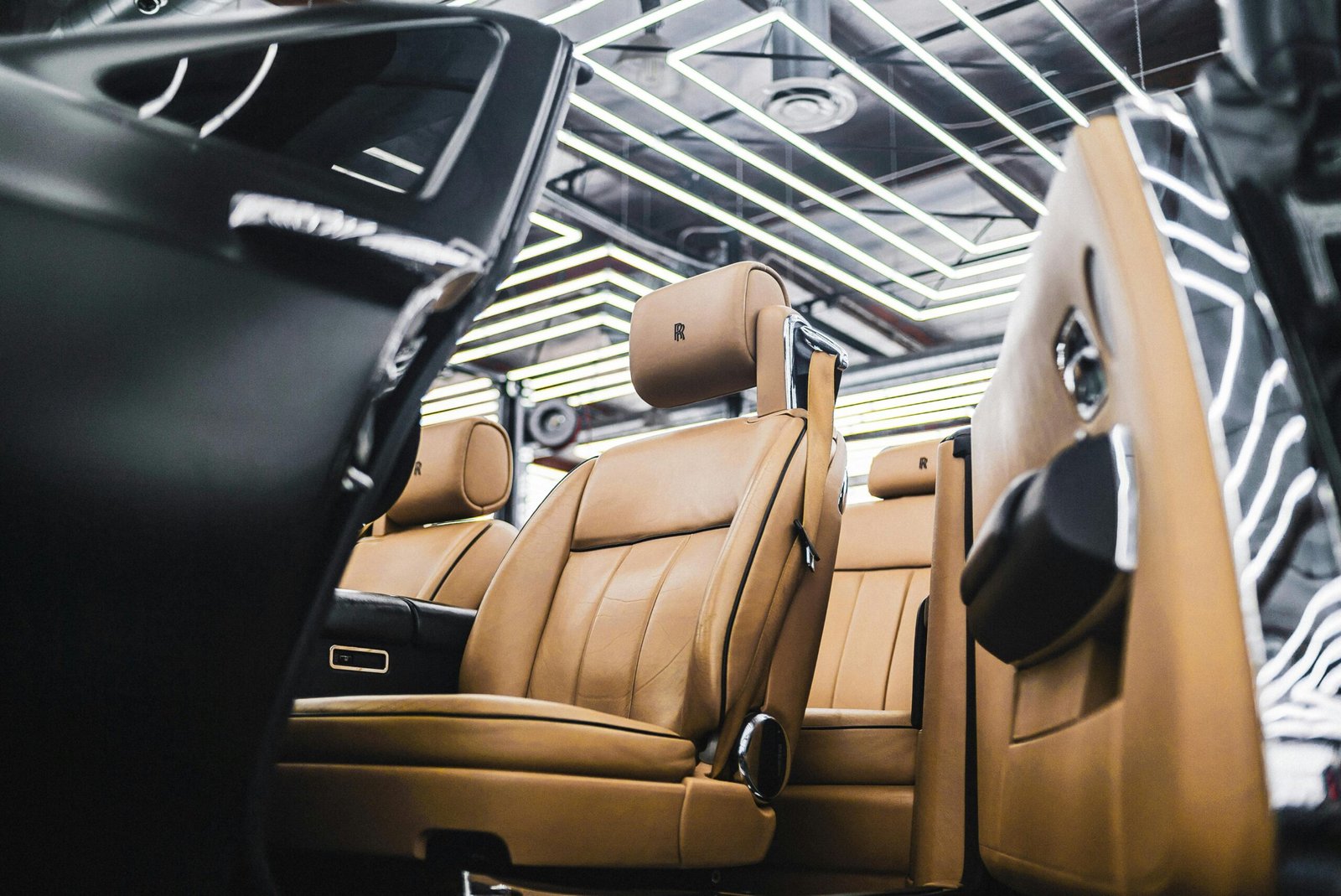 Elegant interior of a luxury car featuring tan leather seats and modern design elements.